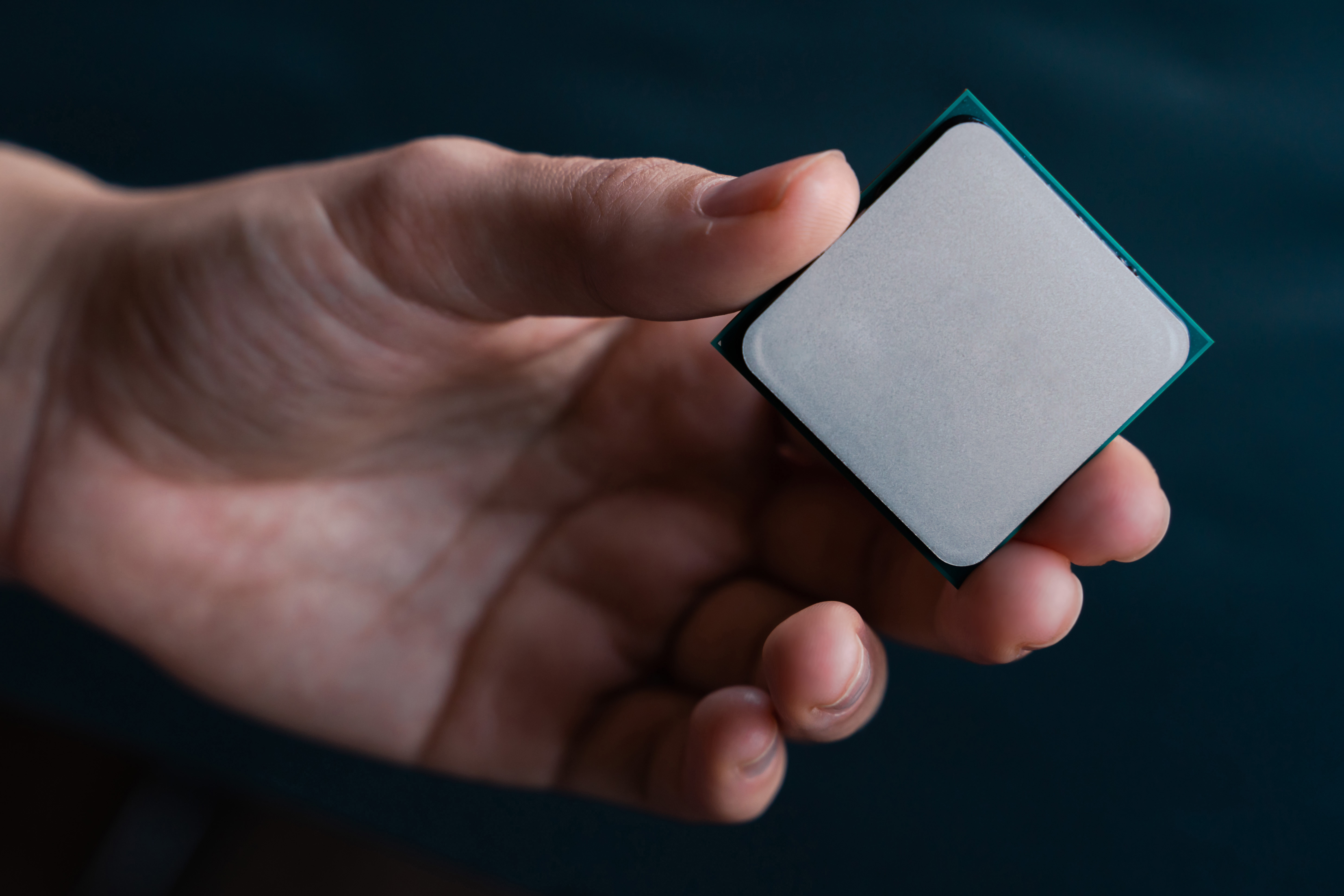 CPU processor held in hand - Intel vs AMD comparison for gaming